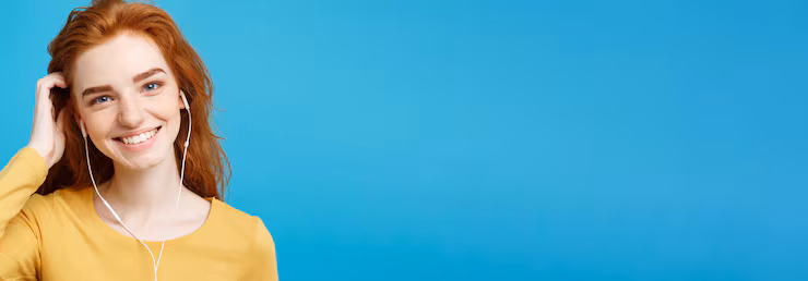 Cheerful young woman smiling with confidence while listening to music, showing the positive impact of a straight smile