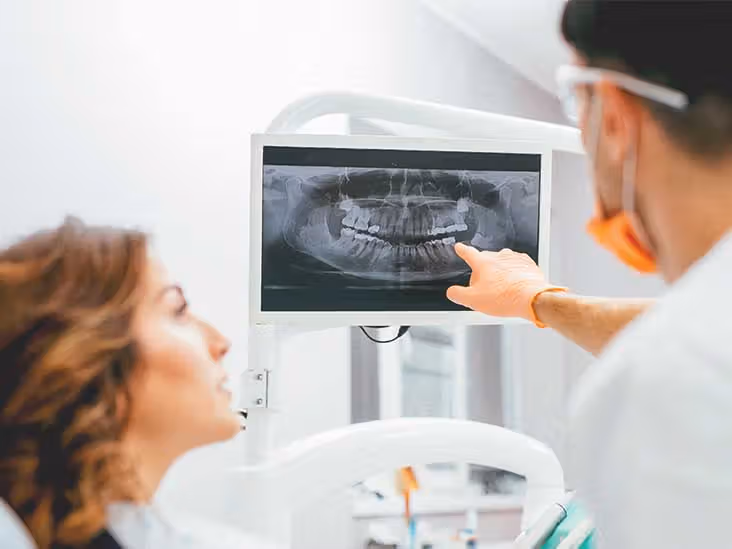 Dentist explaining dental X-ray results to patient to identify hidden oral health issues early